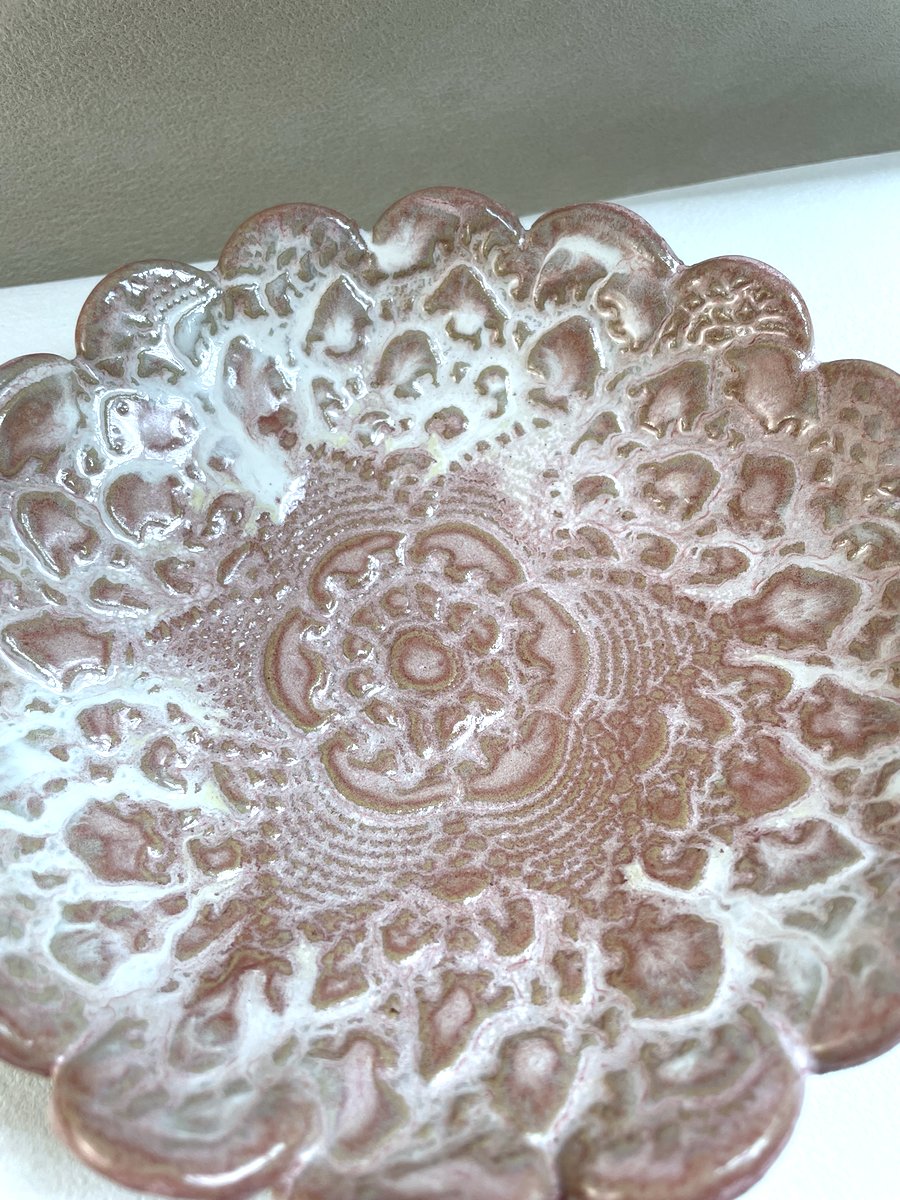 gros plan sur grande coupelle rose avec motif d'une napperon