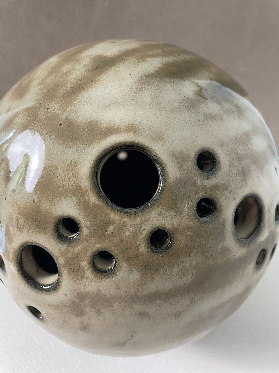 gros plan sur trous  lampe en grès beige saturne