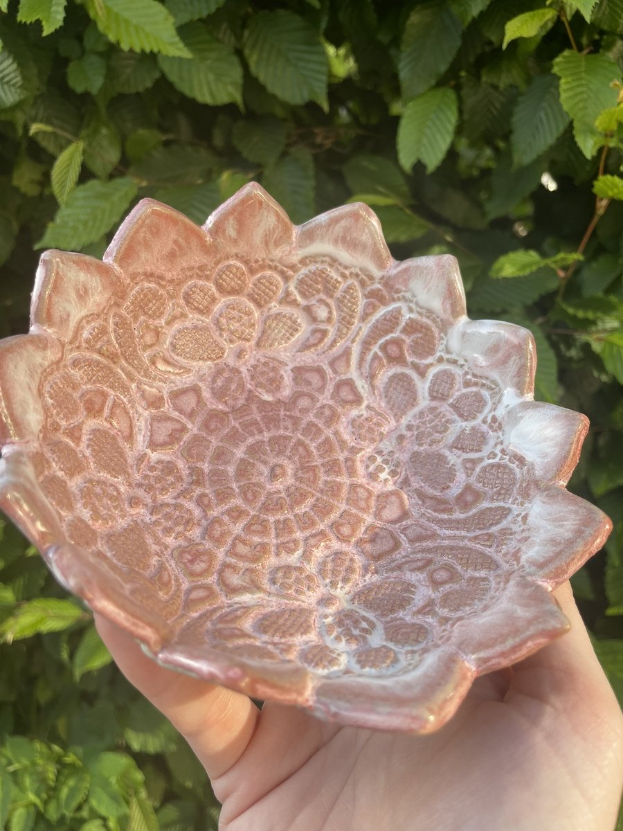 gros plan sur la petite coupelle rose avec des motifs de fleurs en dentelle